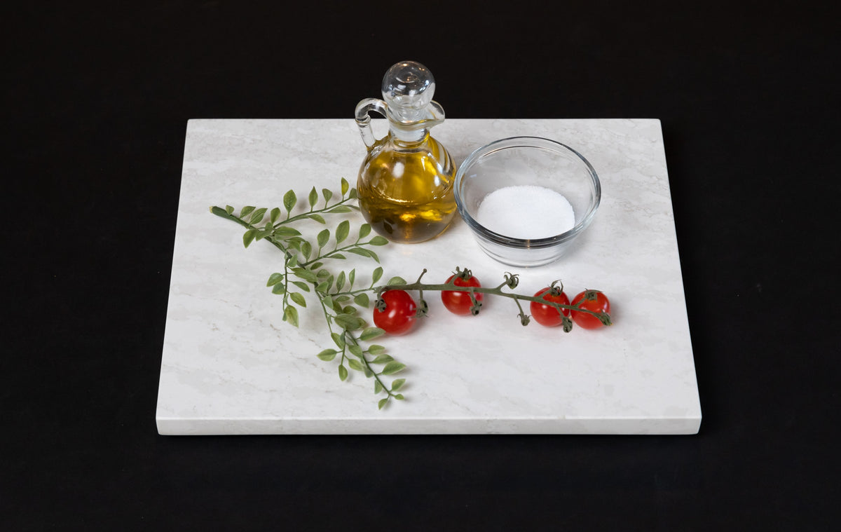 Third Coast Stone quartz cheese board styled with olive oil and tomatoes